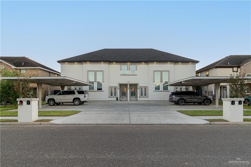 a view of a house with a yard and parking space