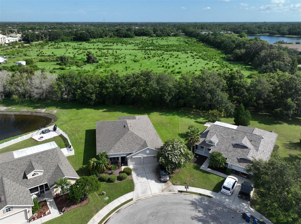 an aerial view of a house with a garden and lake view