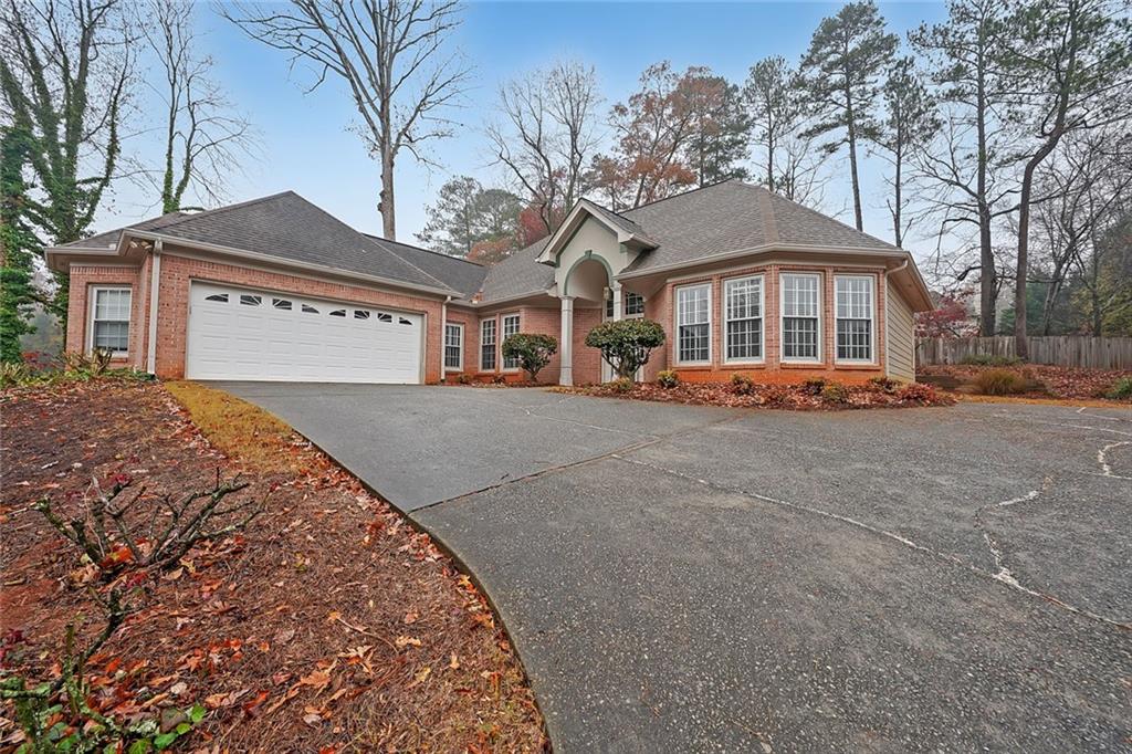 a front view of a house with a yard and large trees