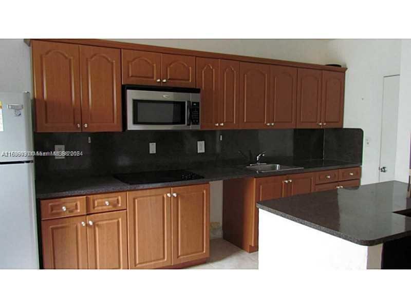 a kitchen with stainless steel appliances a stove a microwave a sink and cabinets