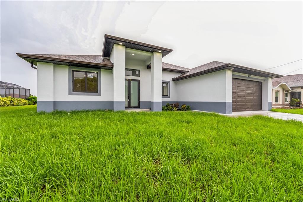 View of front facade with a front lawn and a garage