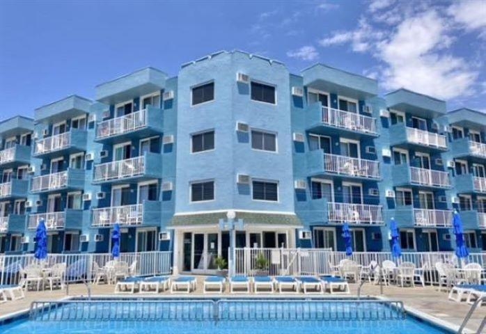 a front view of a building with lake view and lot of large windows