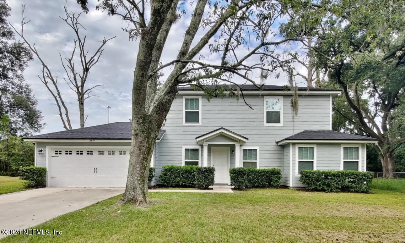 a front view of a house with a yard and garage