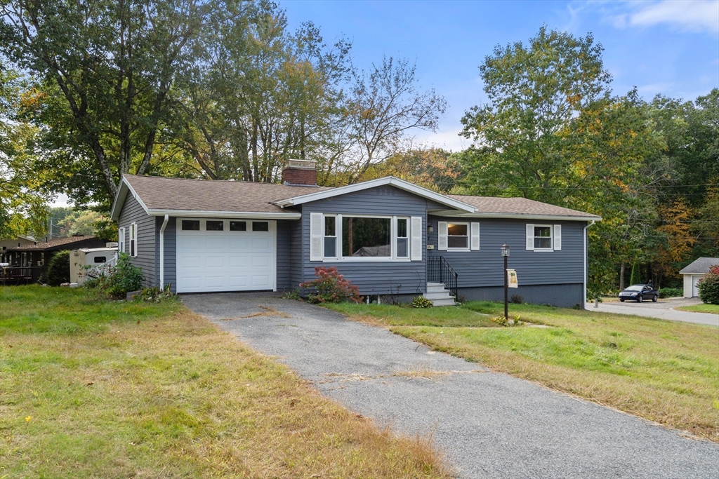 a view of a house with a yard and large tree