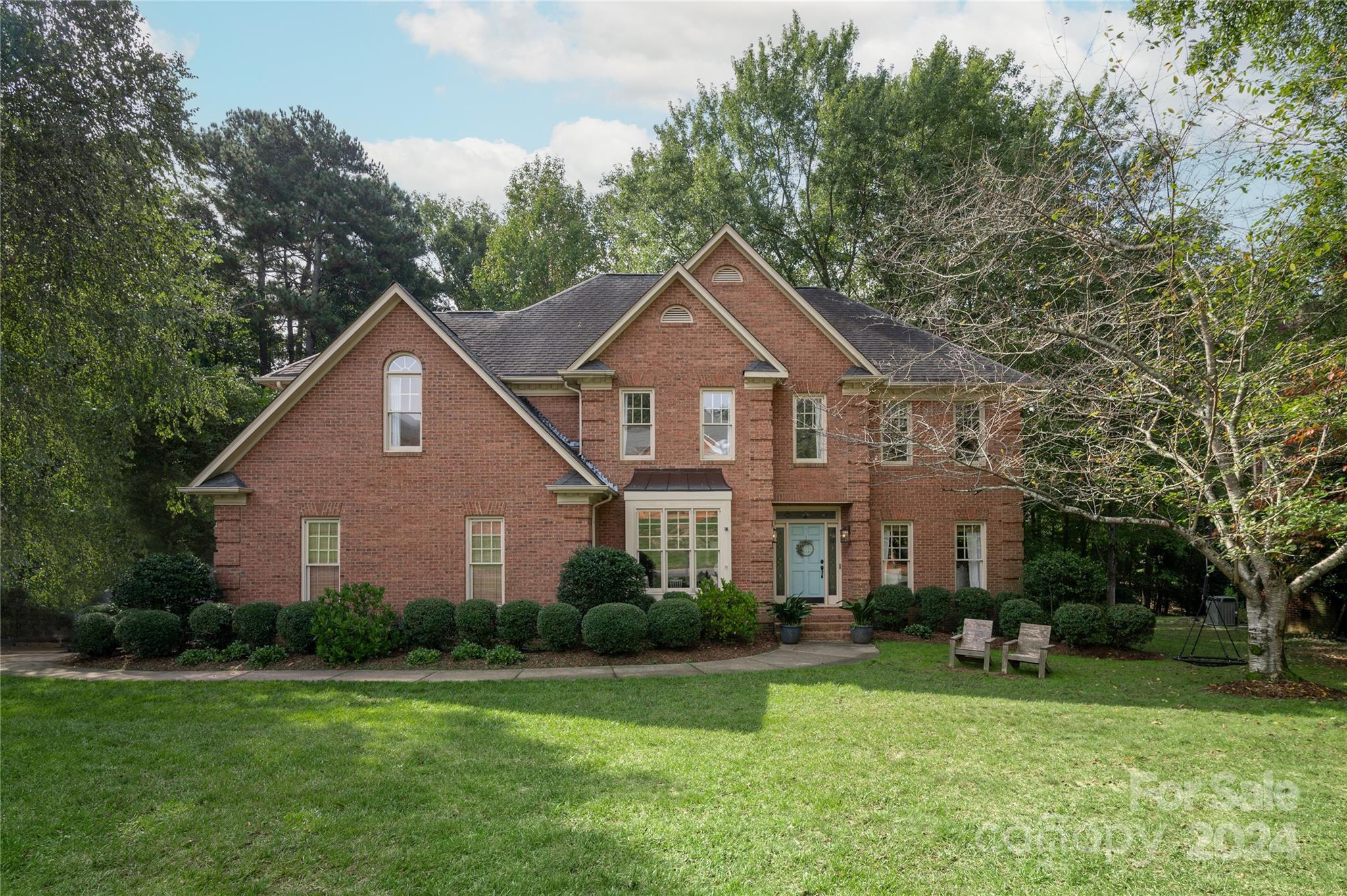 a front view of a house with a yard and trees