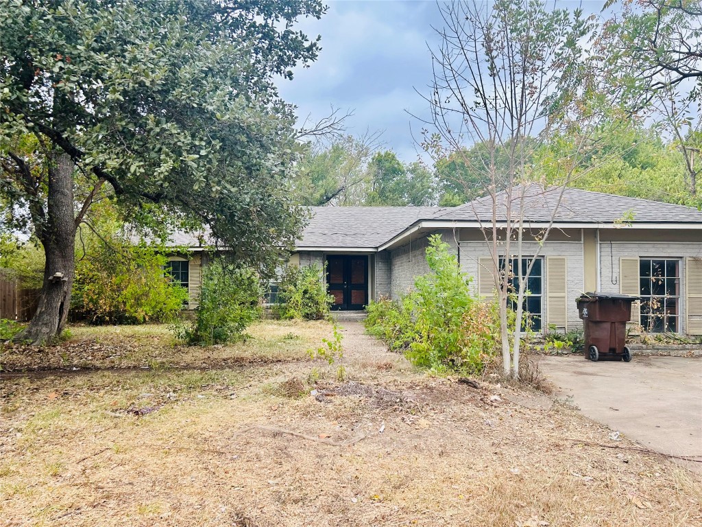 a front view of a house with a yard and shrubs