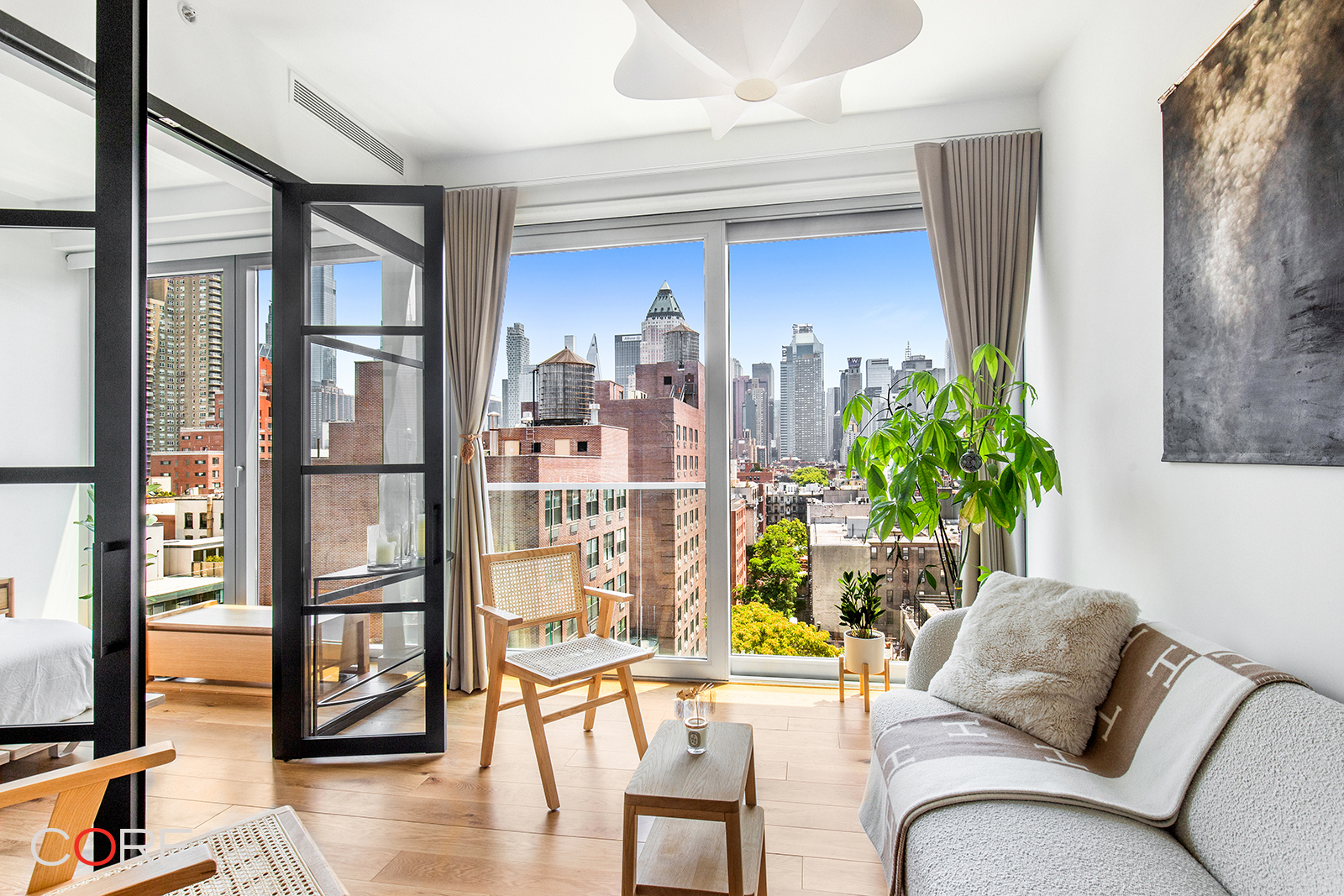 a living room with furniture a flat screen tv and floor to ceiling window