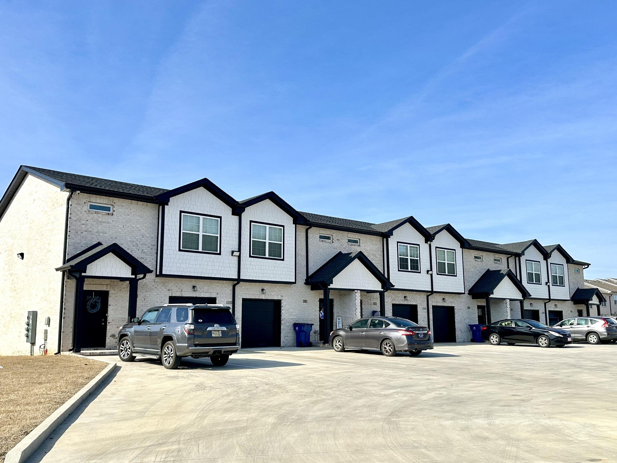 a front view of a house with cars parked