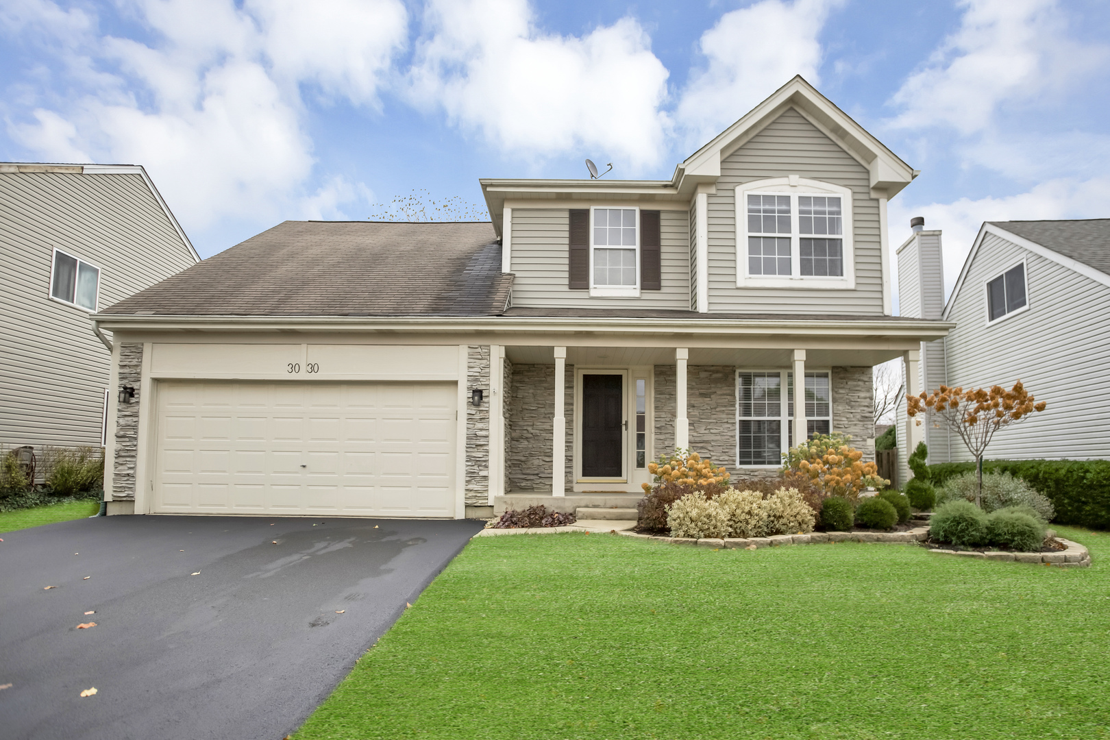 a front view of a house with a garden and plants