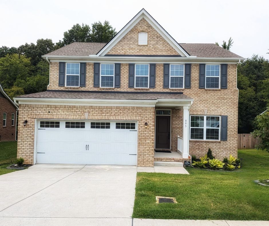 a front view of a house with a yard and garage