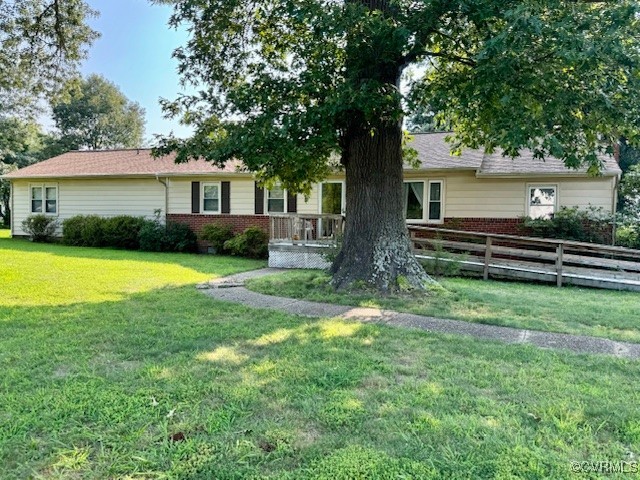 a view of a house with a yard and a large tree