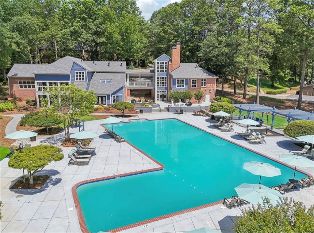 a view of a house with backyard sitting area and swimming pool