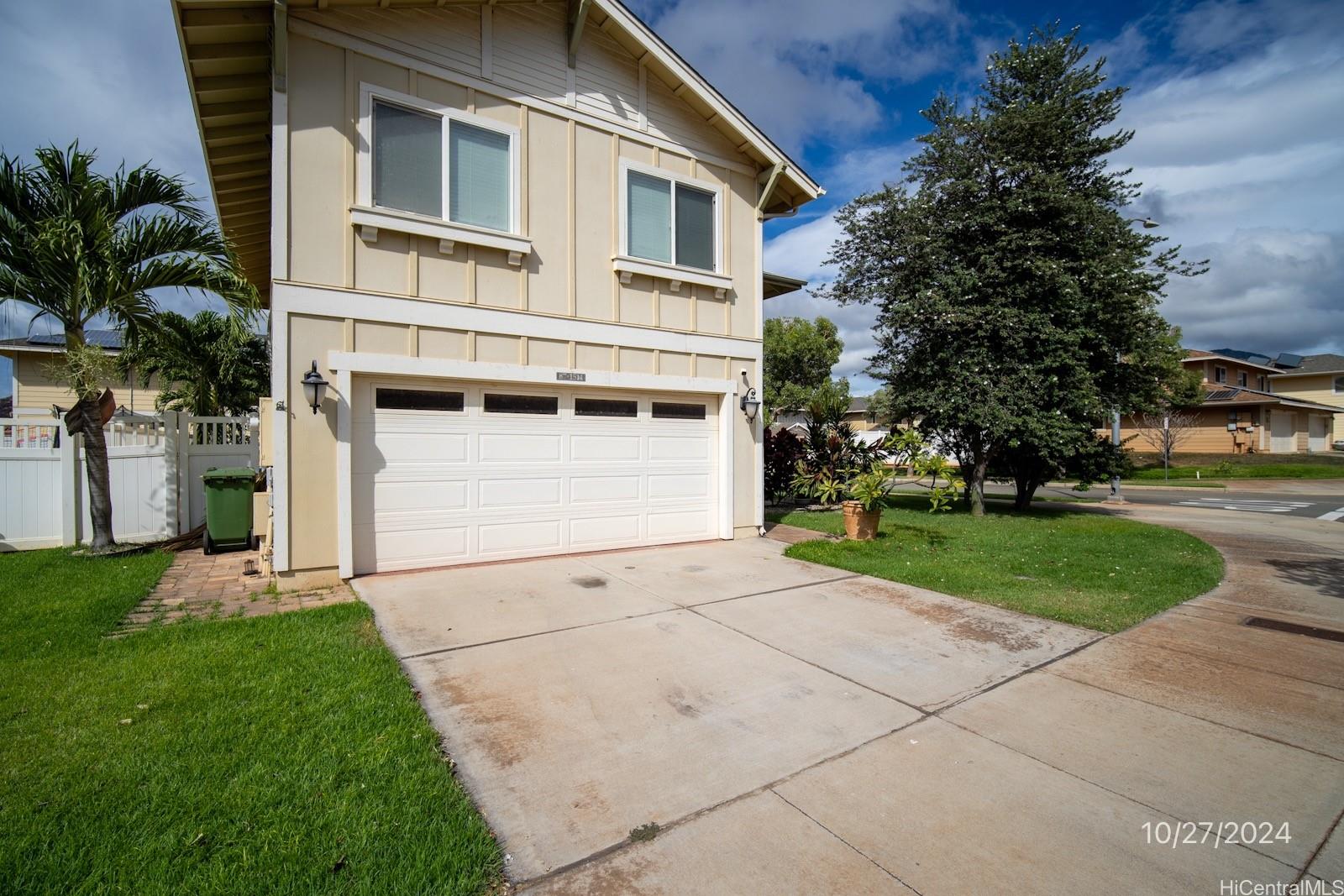 a view of a white house with a yard and garage