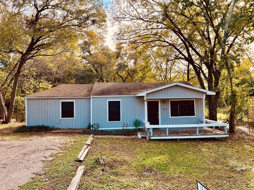 a front view of house with yard and trees around