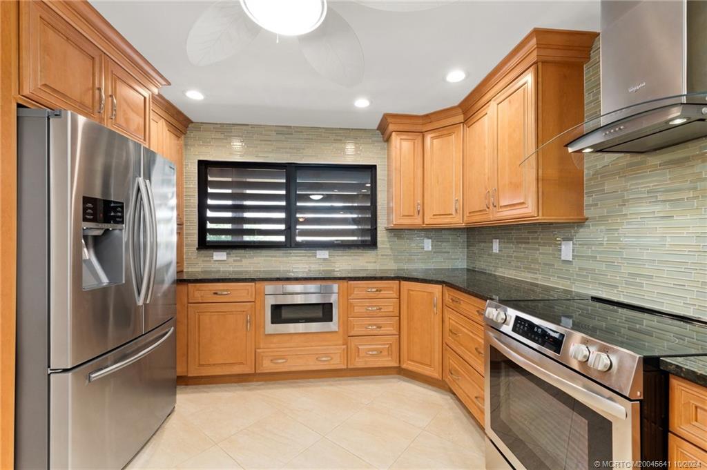 a kitchen with stainless steel appliances granite countertop a refrigerator and a sink