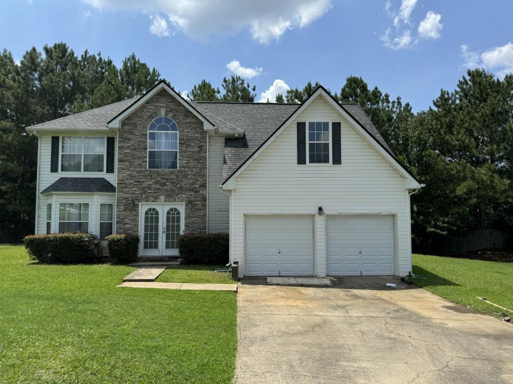 a front view of a house with a yard and garage