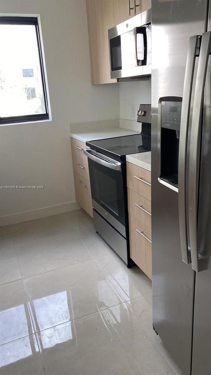 a kitchen with stainless steel appliances a refrigerator and a stove