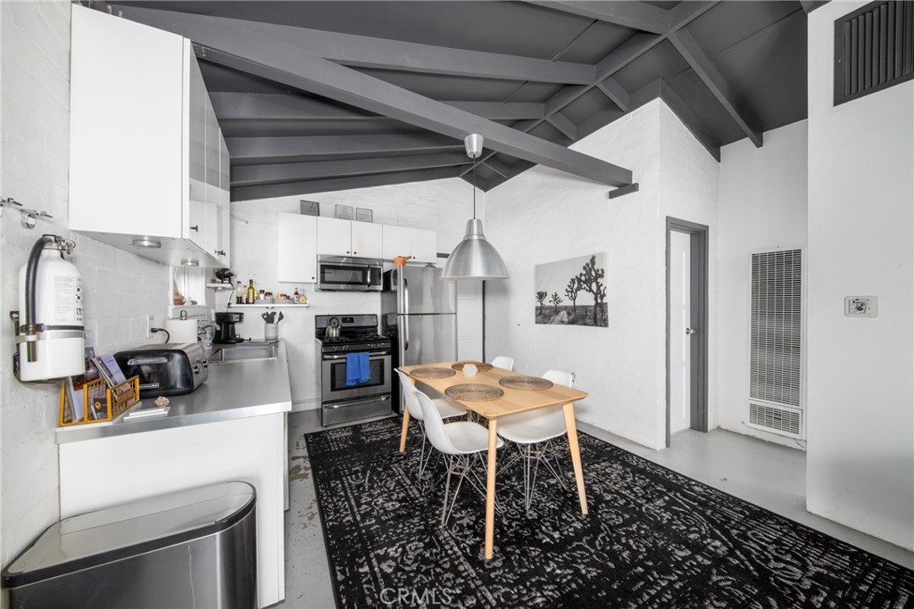 a kitchen with stainless steel appliances kitchen island granite countertop a sink and a refrigerator