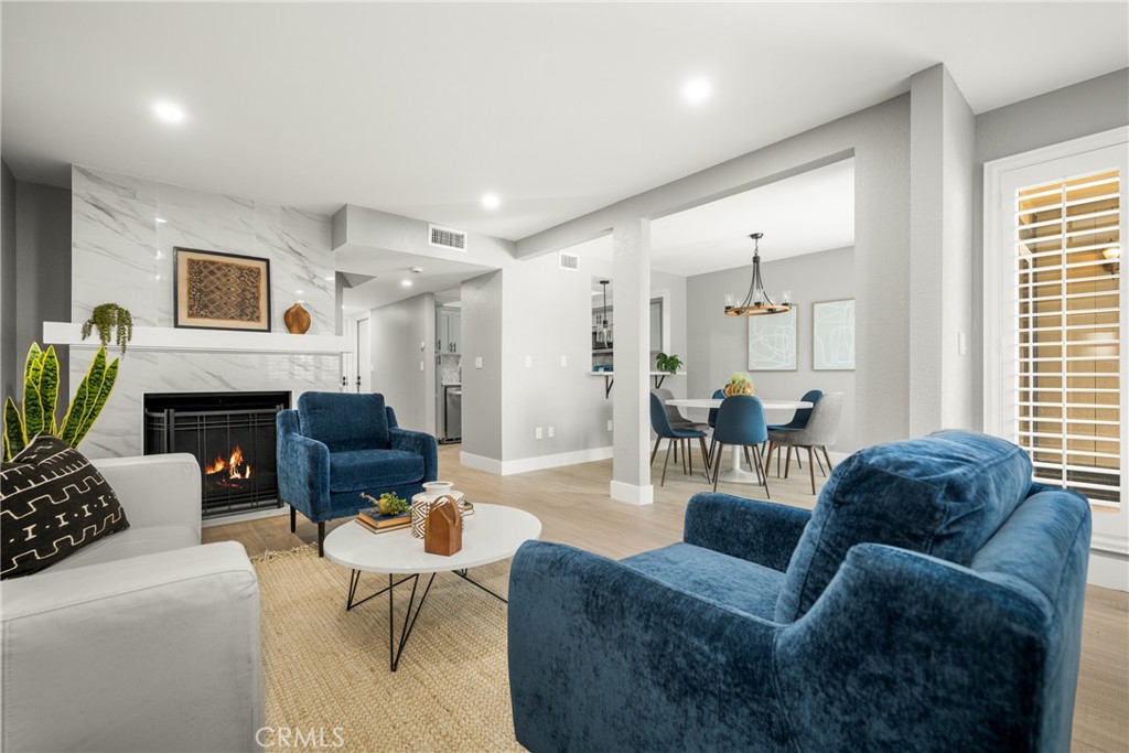 a living room with furniture a fireplace and a window