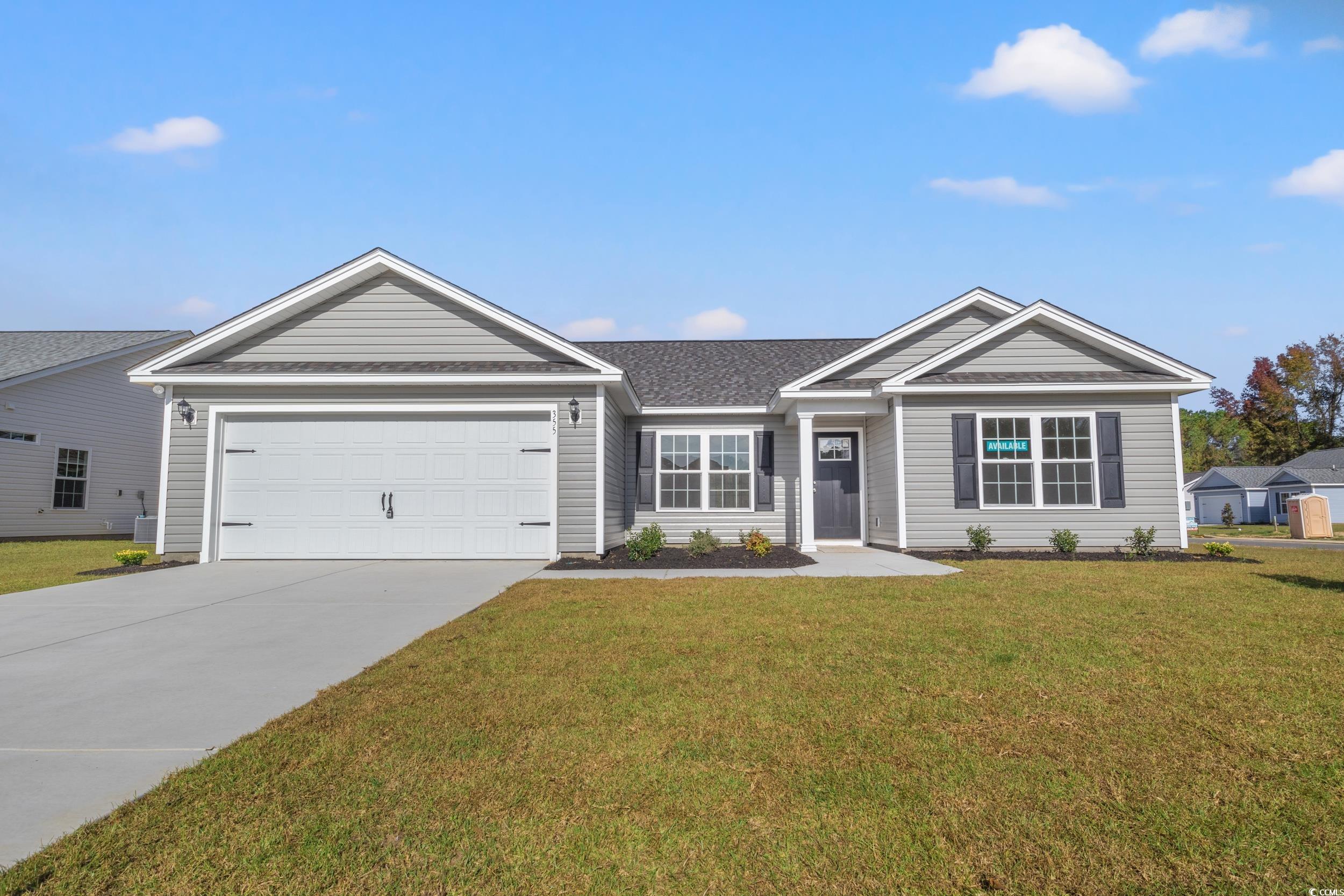 Ranch-style house featuring a front lawn and a gar