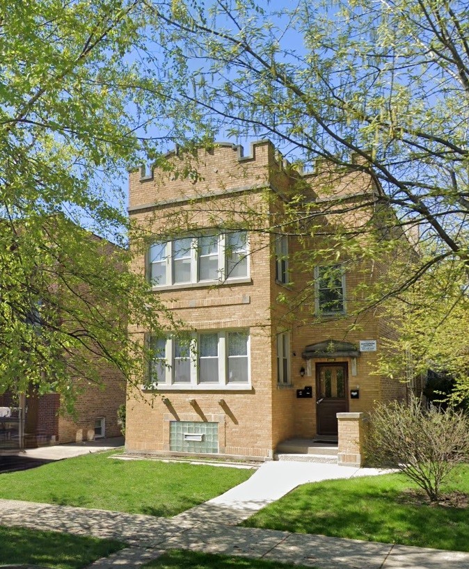 front view of a brick house with a yard