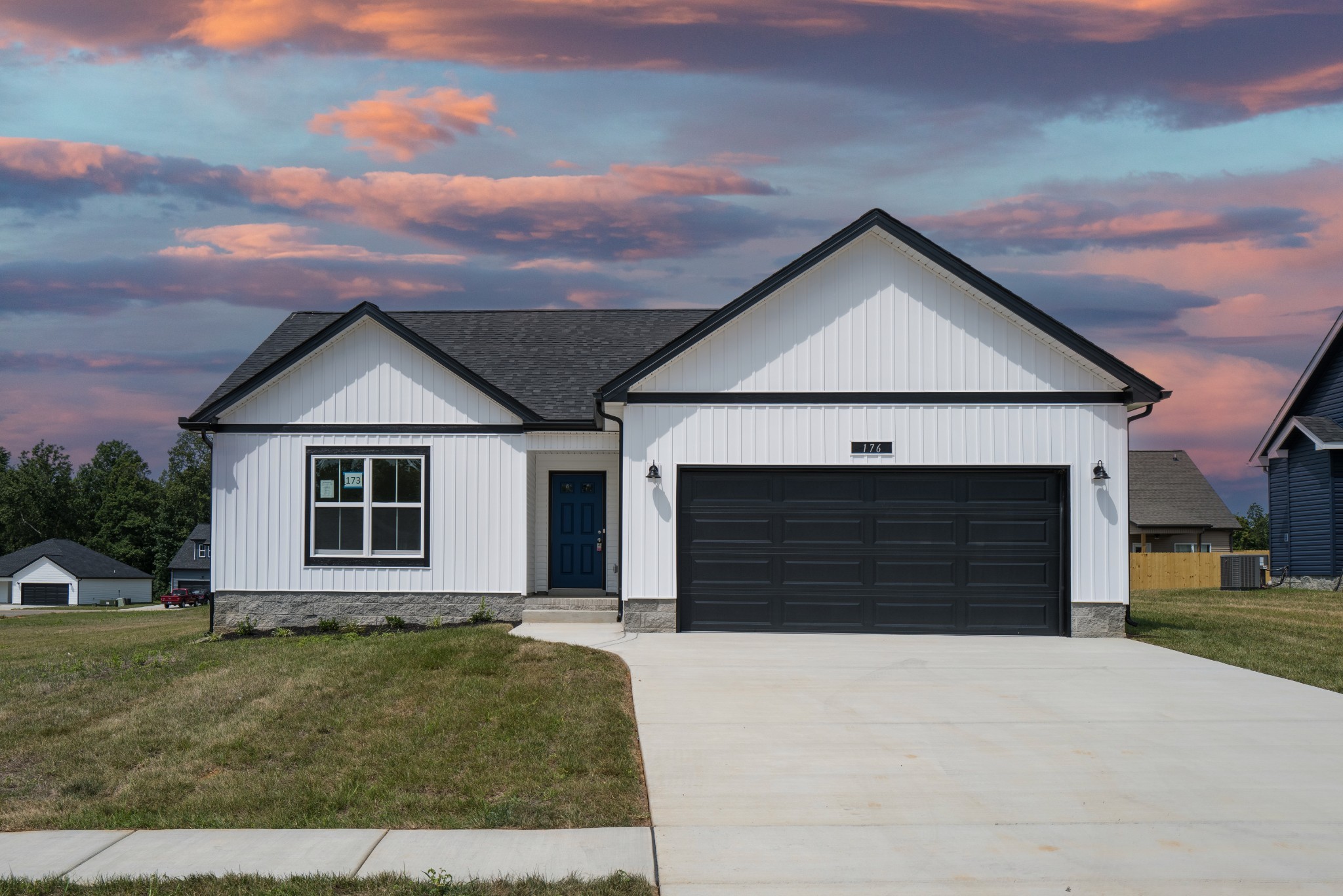 front view of a house with a yard and garage