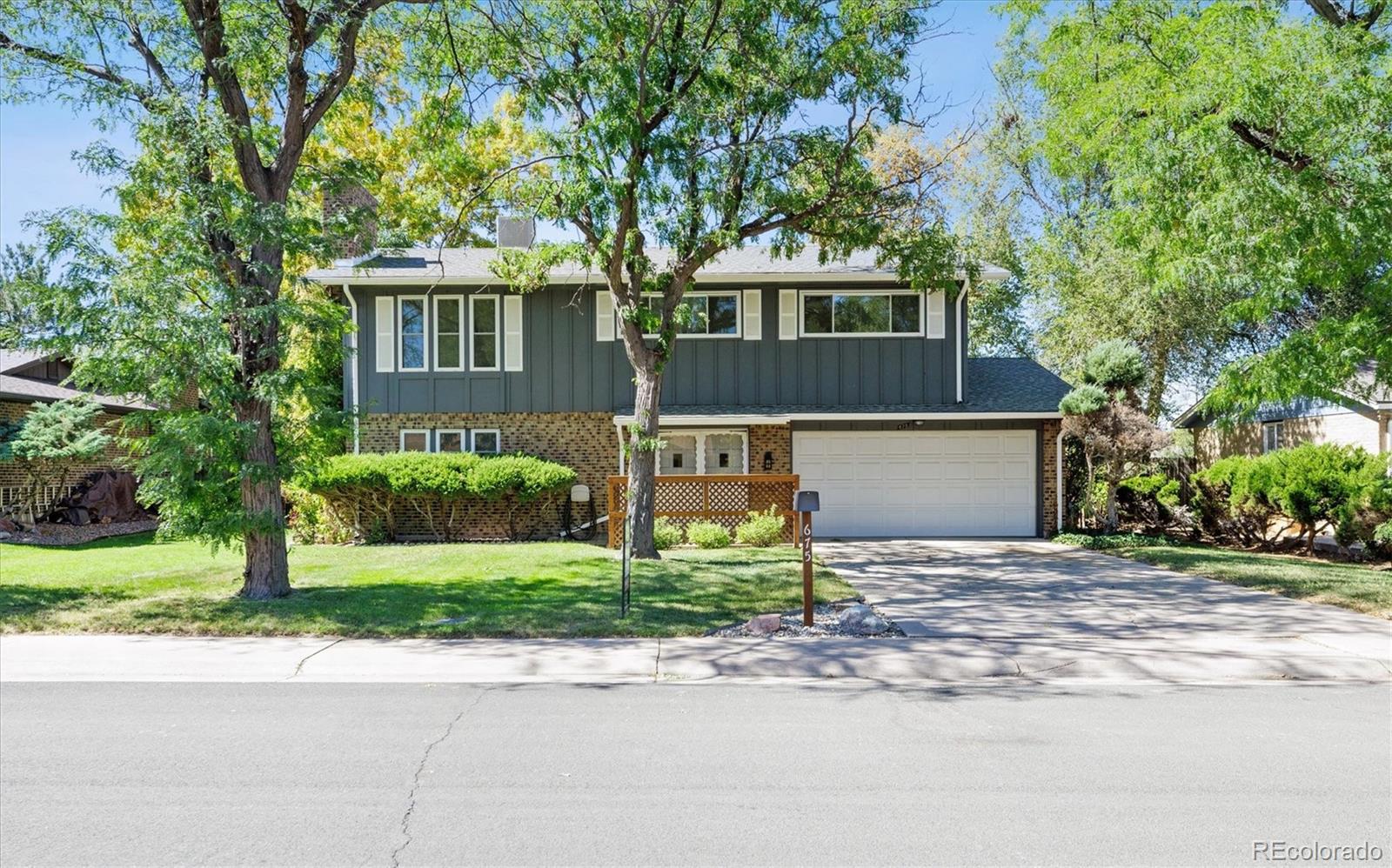 a front view of a house with a yard and a garage