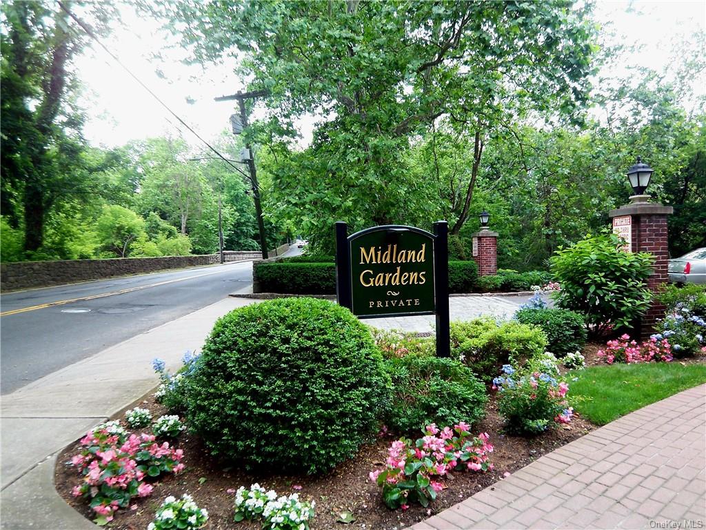 a view of sign board with flower in a yard