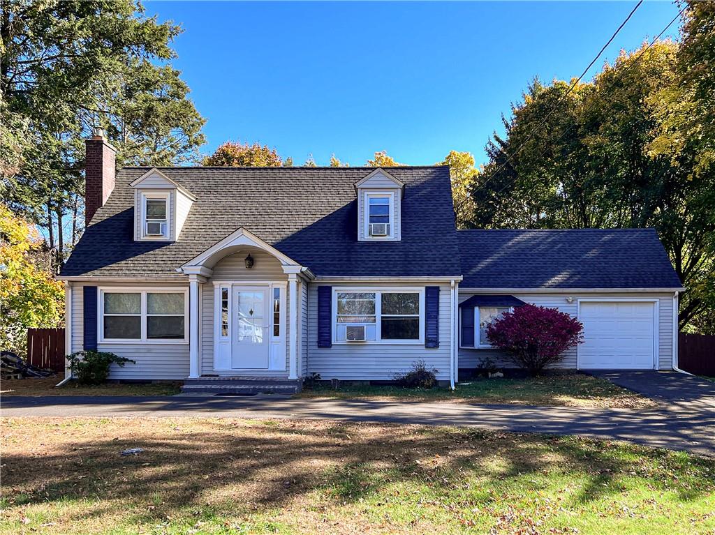 Cape cod home featuring a front lawn