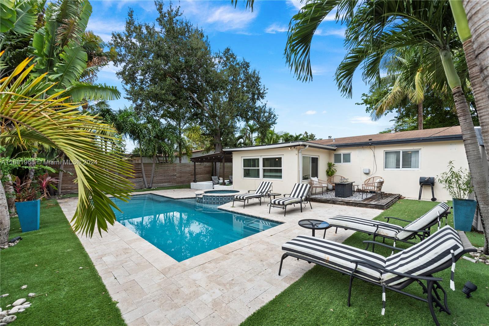 a view of a patio with couches and a table and chairs with wooden floor and fence