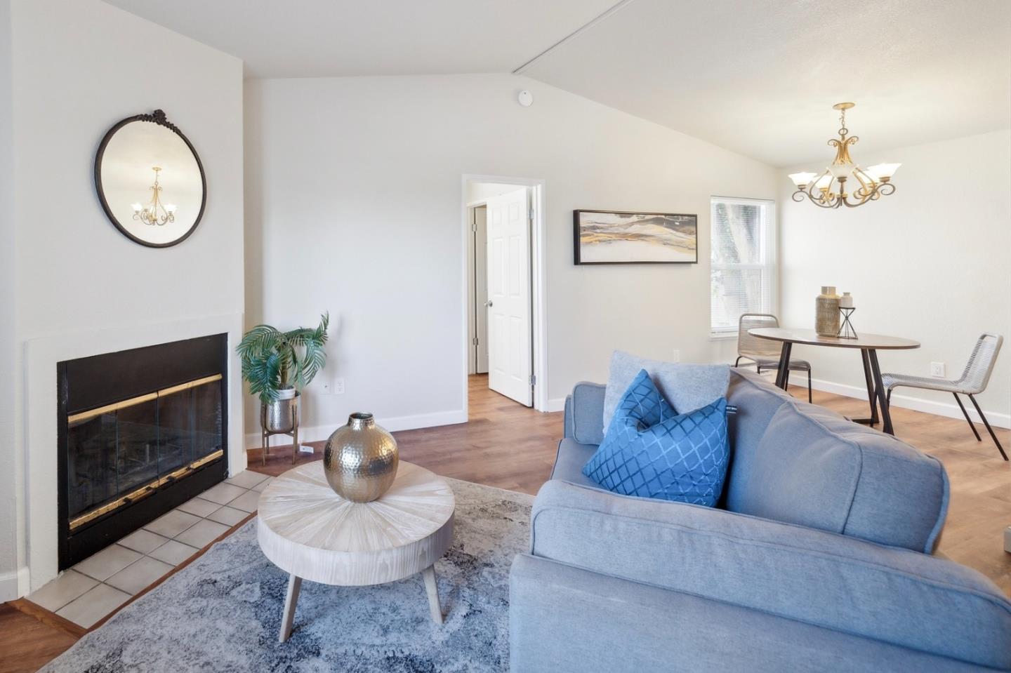 a living room with furniture a fireplace and a mirror