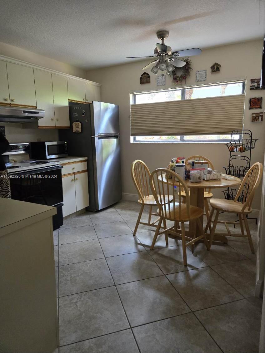 a kitchen with granite countertop a refrigerator and a stove top oven