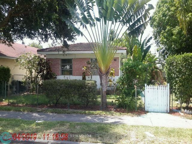 a front view of a house with a yard and tree