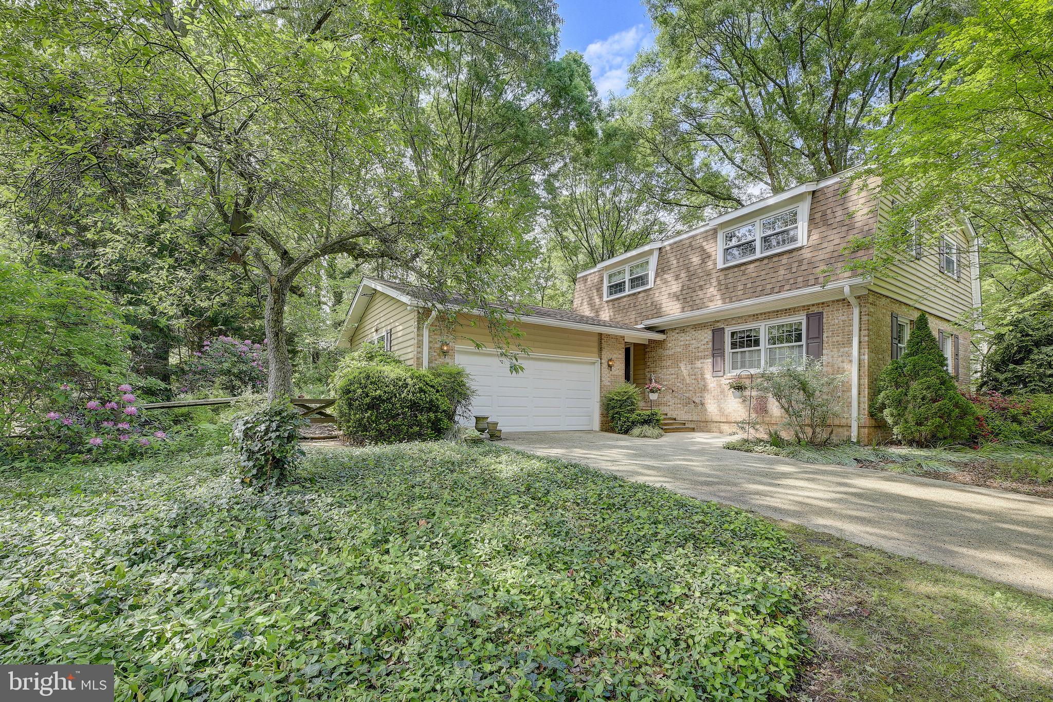 a view of a house with a yard and large tree