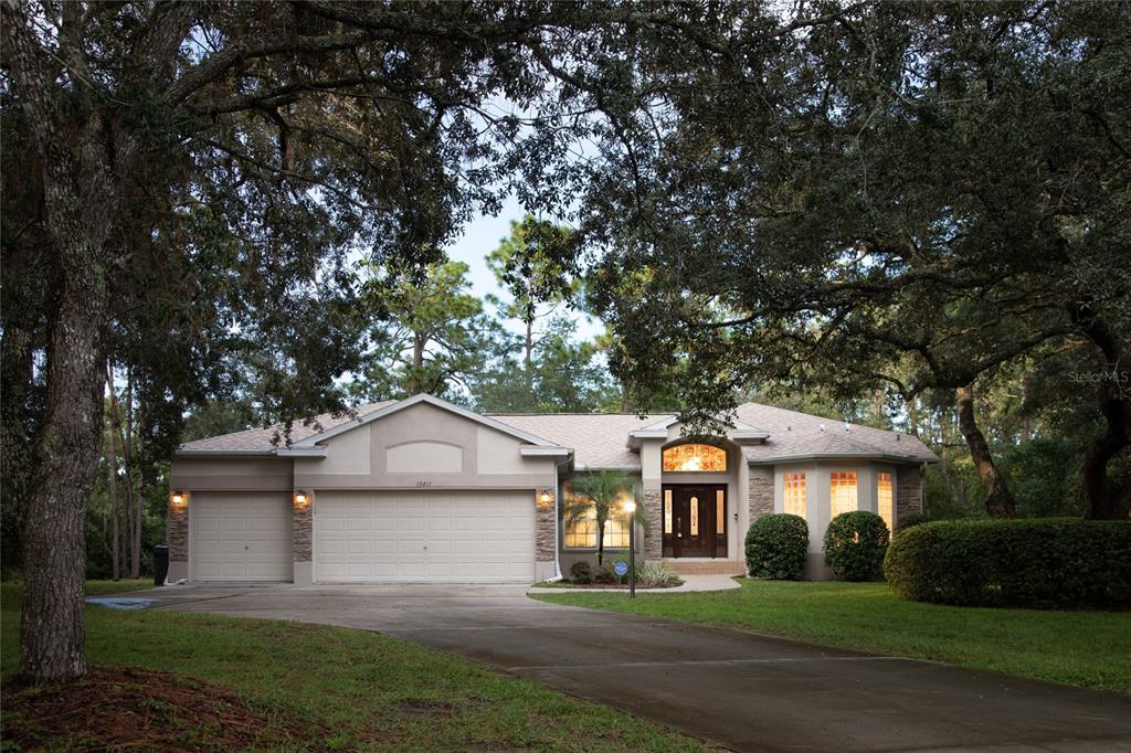 a front view of a house with a yard and trees