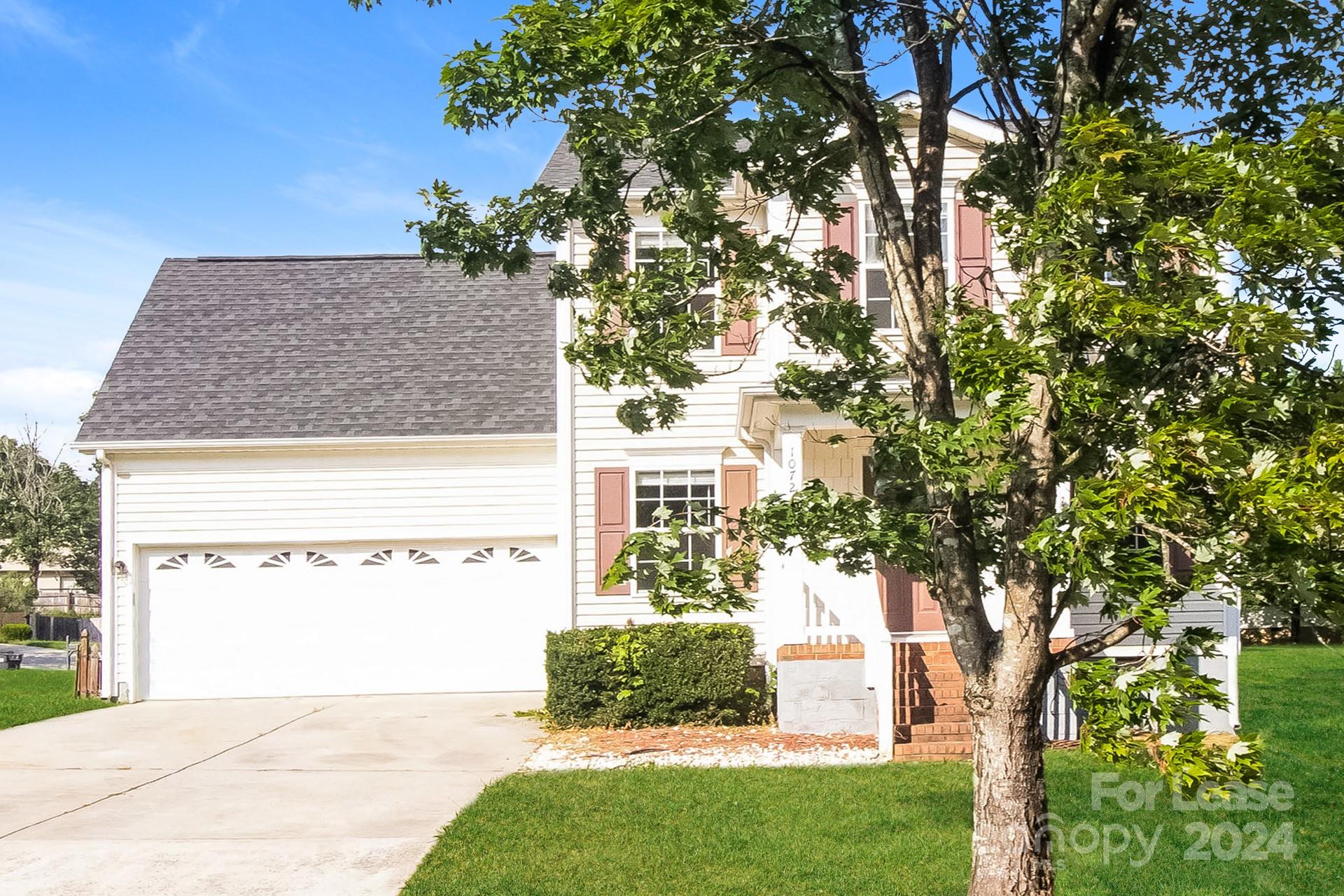 a view of a house with a tree in front of it