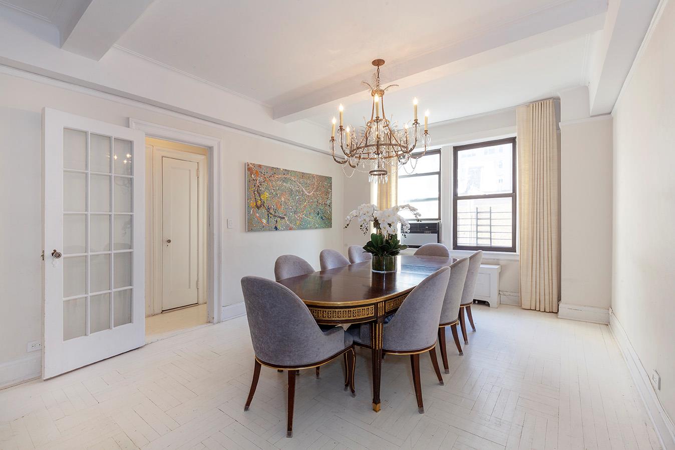 a view of a dining room with furniture a chandelier and window