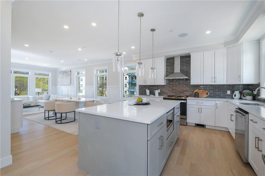 a kitchen with kitchen island granite countertop a sink and white cabinets