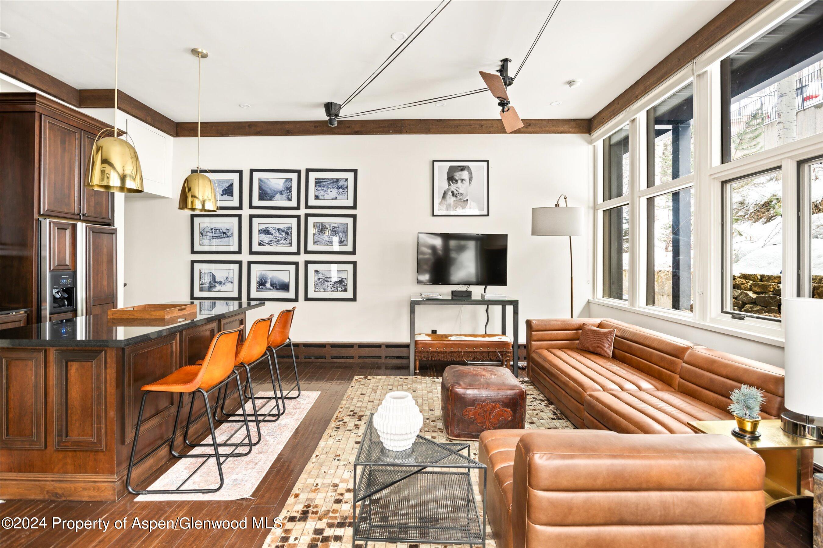 a living room with furniture a flat screen tv and a floor to ceiling window