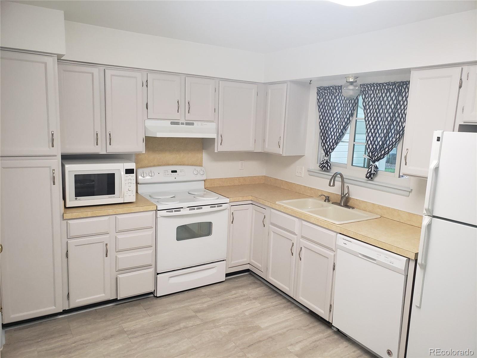 a kitchen with white cabinets sink and white appliances