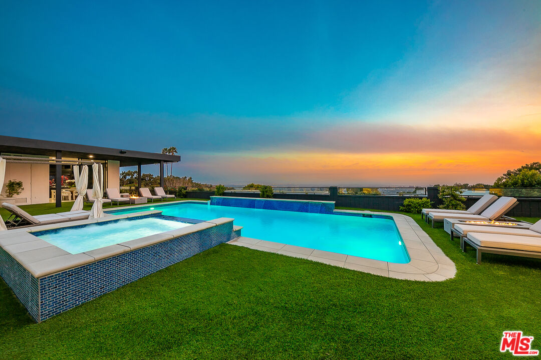 a view of swimming pool with lounge chairs in patio