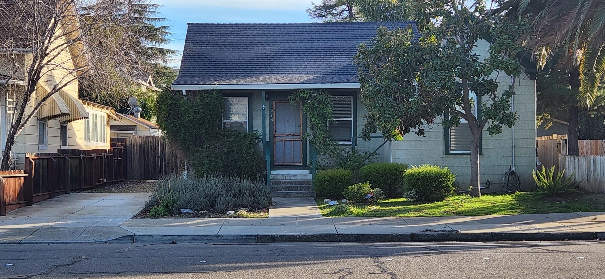 a front view of a house with garage and plants