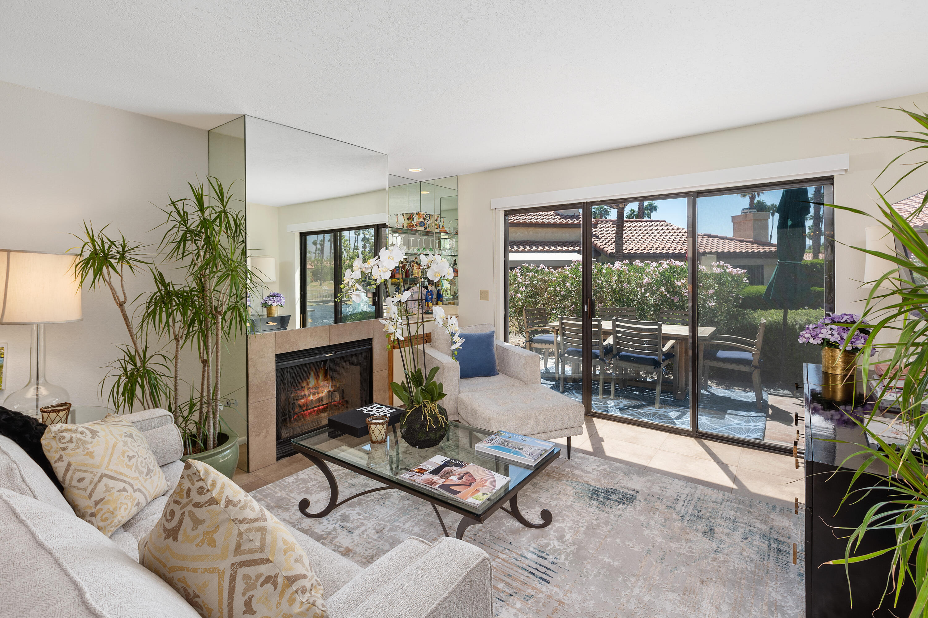 a living room with furniture a flat screen tv and a floor to ceiling window