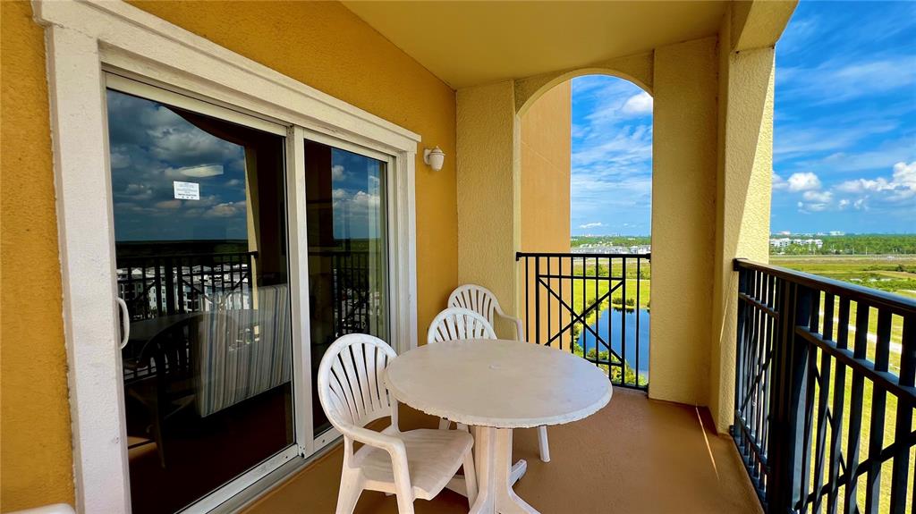 a balcony with table and chairs