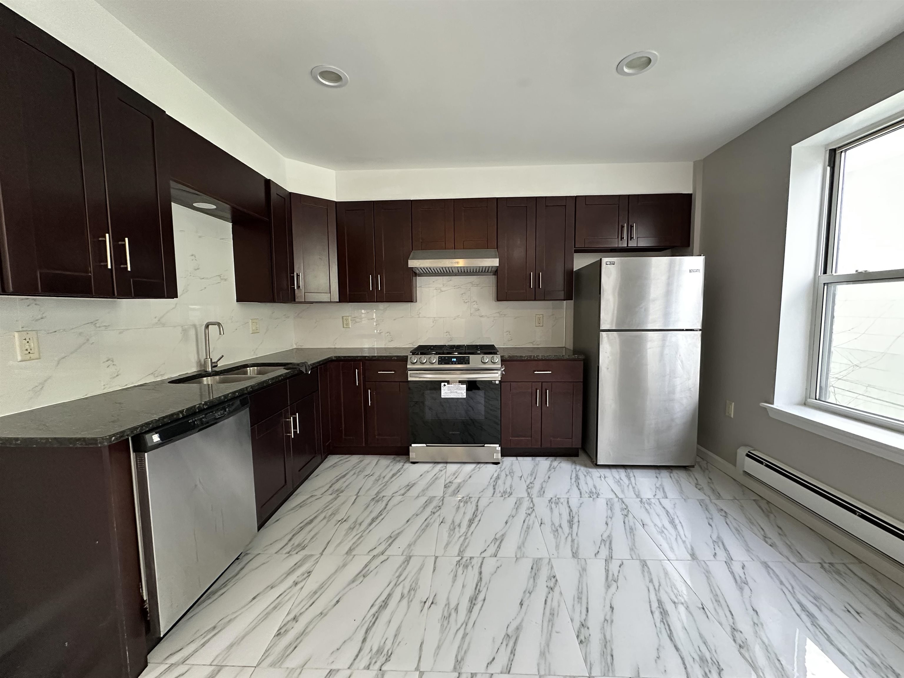 a kitchen with a refrigerator a sink and wooden cabinets