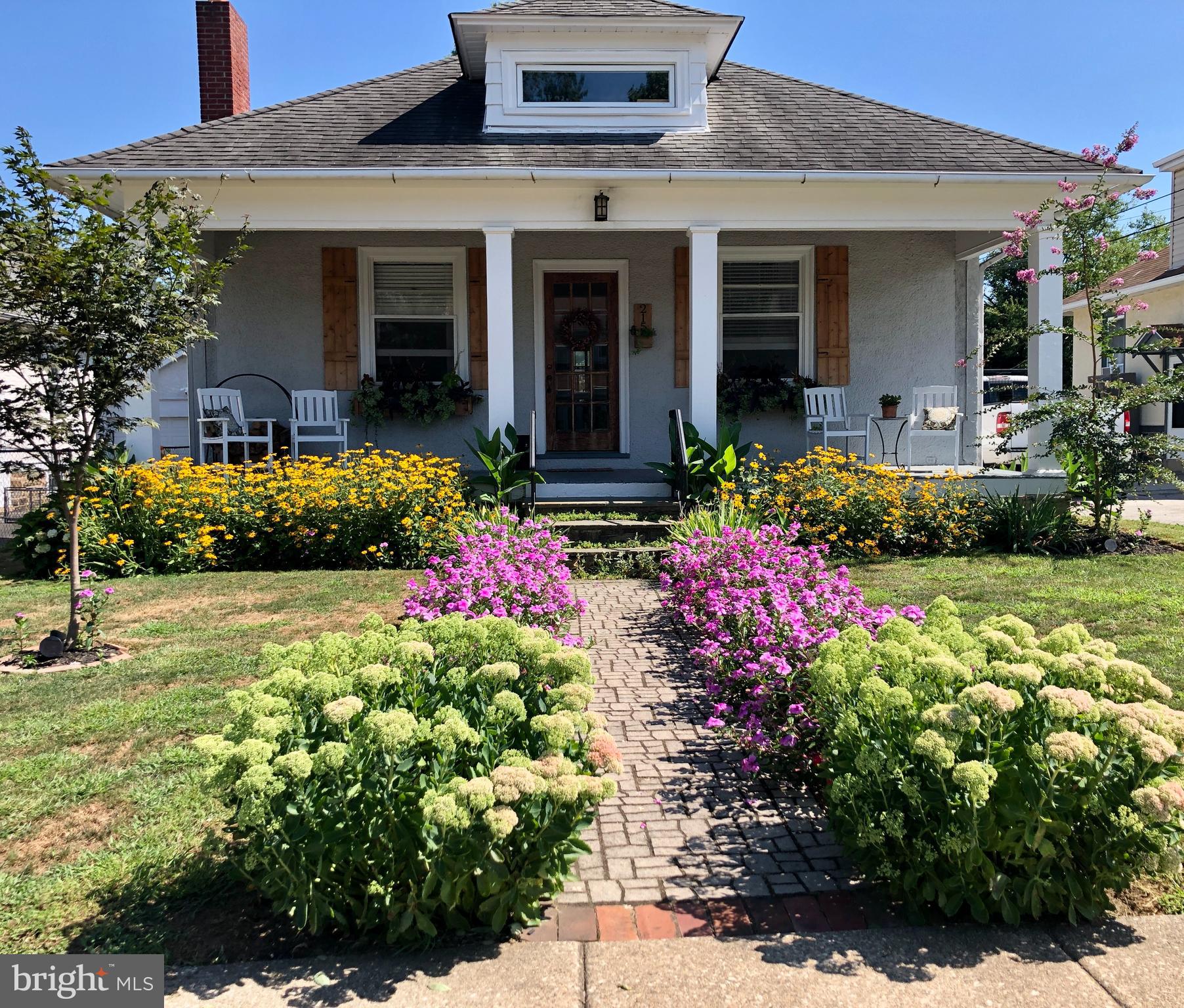 a front view of a house with a yard and a garden