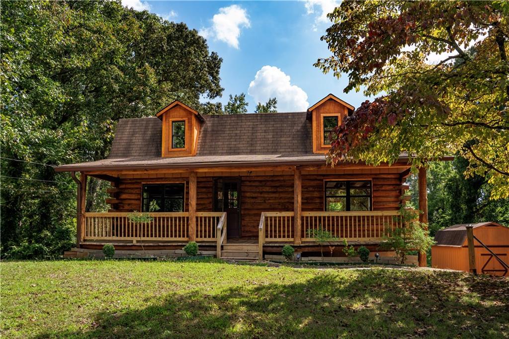 a view of a house with a yard balcony and a tree