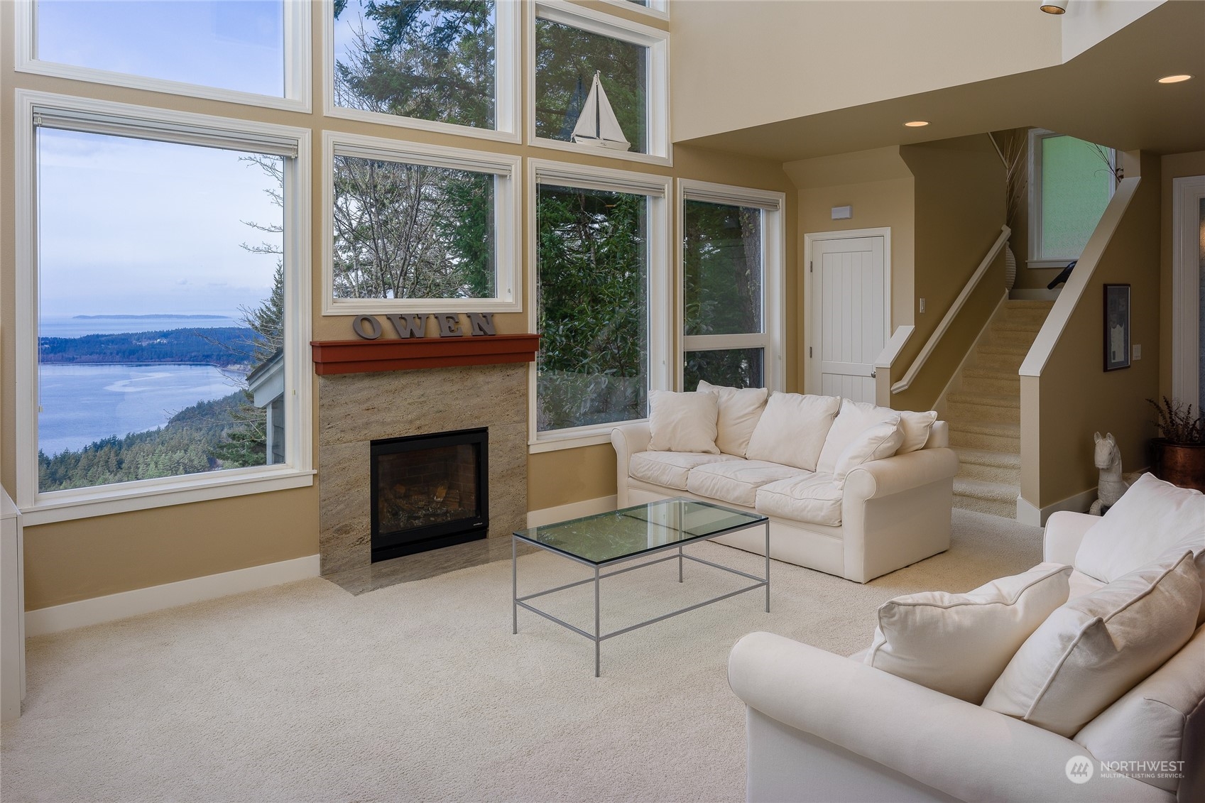 a living room with furniture a fireplace and a floor to ceiling window