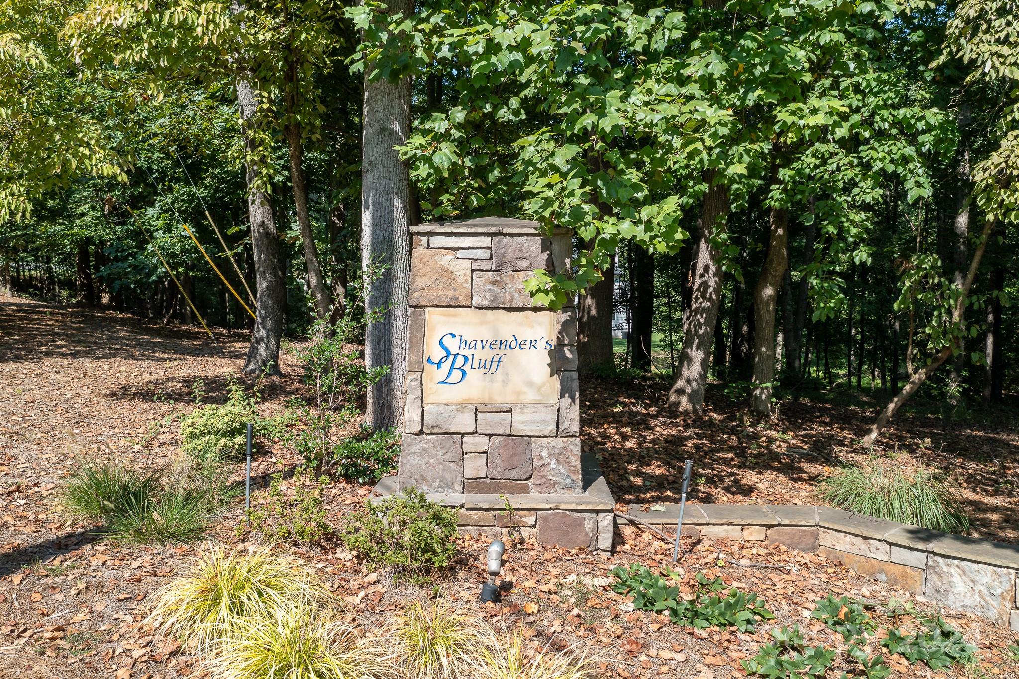 a sign board with tall trees