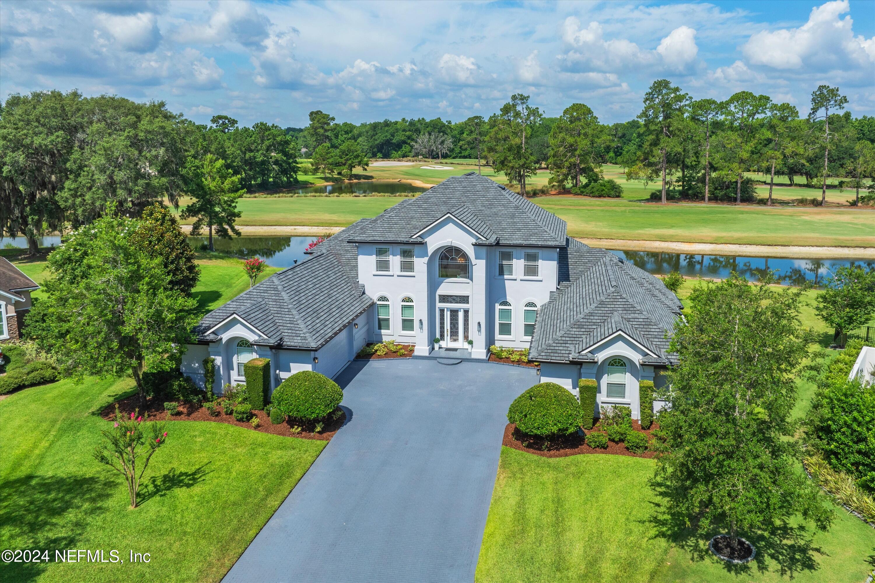 a aerial view of a house with big yard and large trees